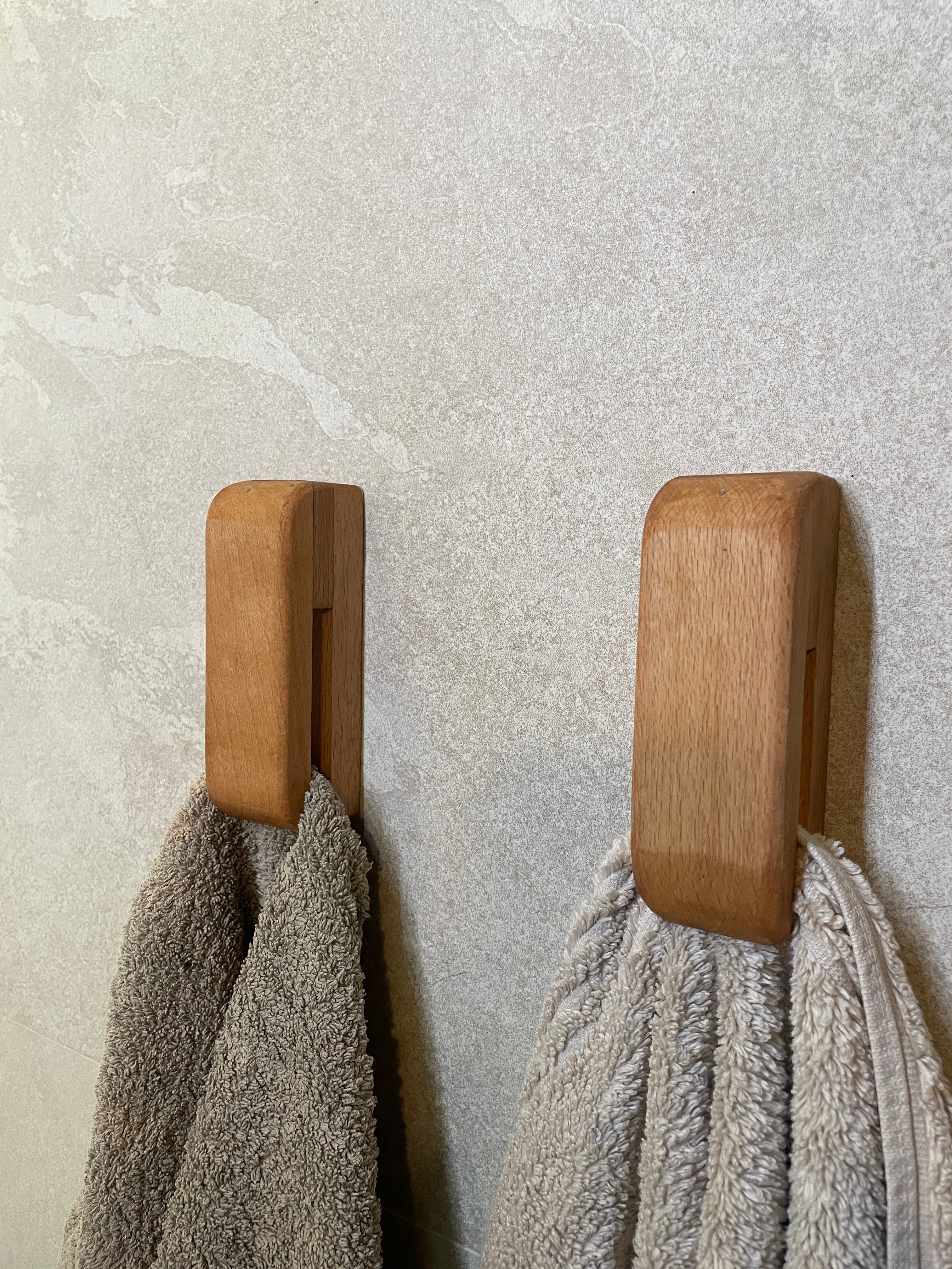 Two wooden towel hooks holding towels