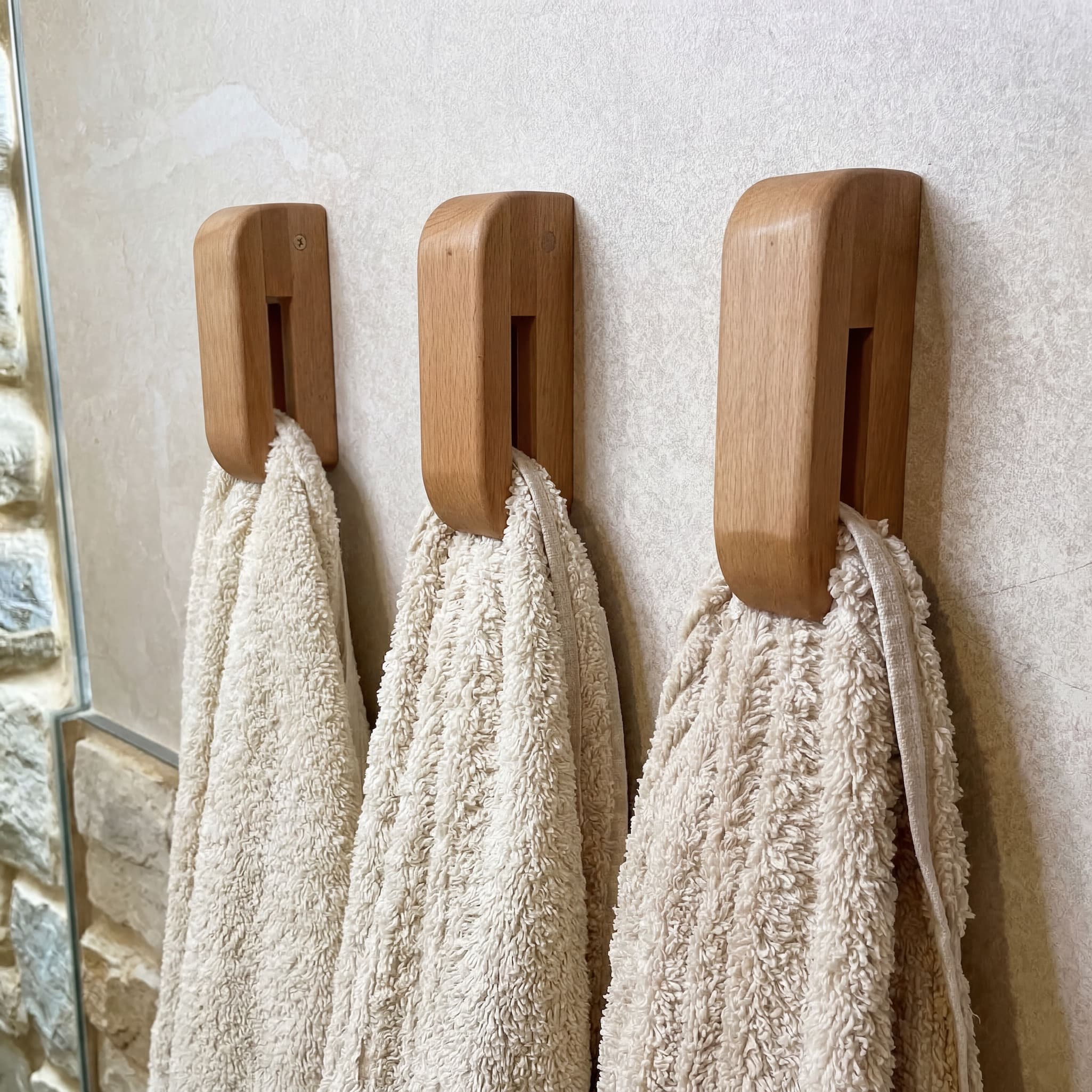 Wooden towel hooks with towels on wall